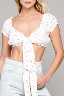 woman standing wearing white crop top and jeans