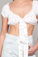 woman standing wearing white crop top and jeans