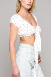 woman standing wearing white crop top and jeans