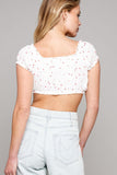 back of a woman standing wearing white crop top and jeans